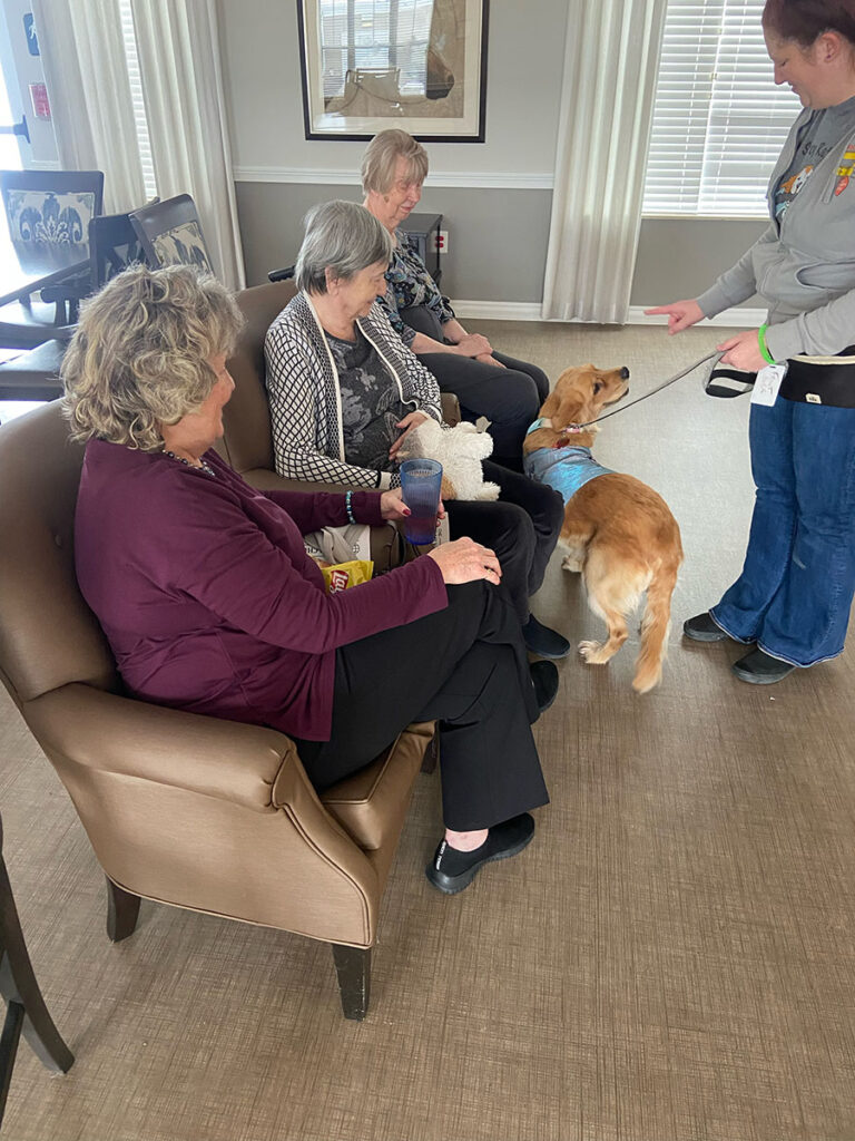Memory care residents bonding with a therapy dog.