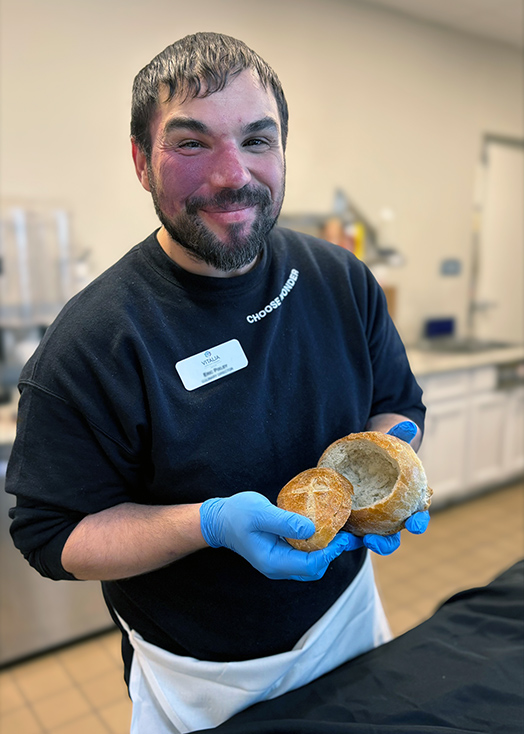 Culinary Director at Vitalia Westlake smiles, displaying a house-made bread bowl.
